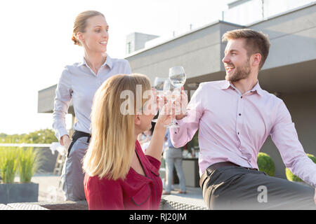 Lächelnden jungen Kollegen toasten Weingläser während Erfolg Party auf dem Dach Stockfoto
