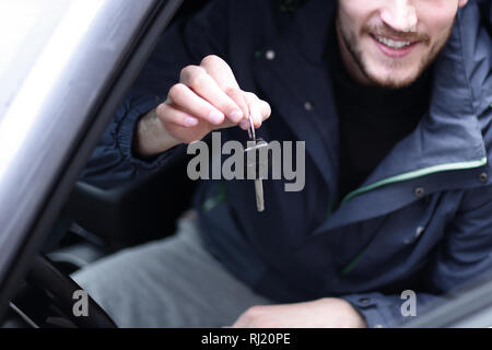 Hübscher junger Mann, der die Schlüssel des neuen Auto Stockfoto