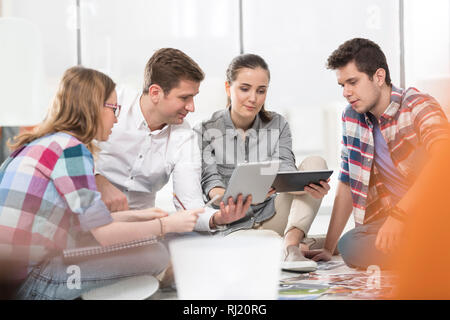 Creative Business Kollegen mit digitalen Tabletten und Fotografien im Büro Stockfoto