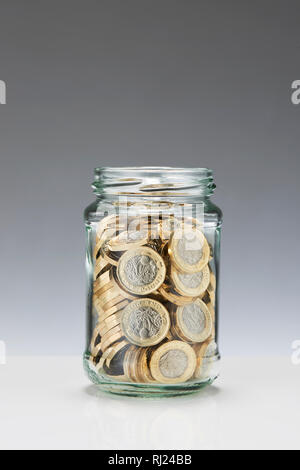 Einsparungen aus Glas Glas mit einem Pfund Münzen Stockfoto