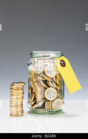 Einsparungen aus Glas Glas mit einem Pfund Münzen Stockfoto
