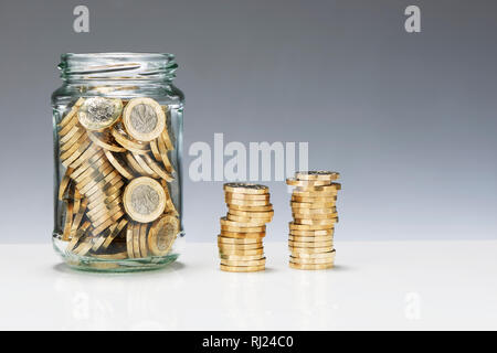 Einsparungen aus Glas Glas mit einem Pfund Münzen Stockfoto