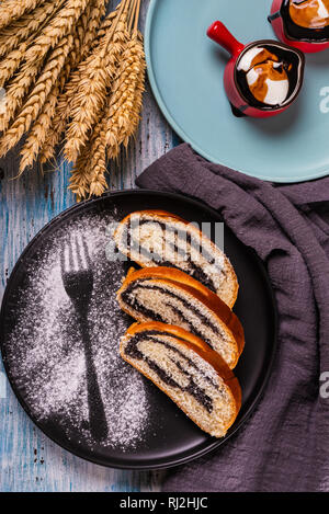 Poppy seed Strudel auf dunklen Platte mit Silhouette der Gabel durch Zucker Stockfoto