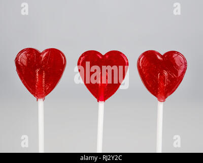 Drei rote, herzförmige Lutscher. Verschwommenen Hintergrund, Valentine's Karte. Stockfoto