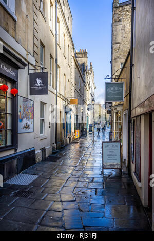 Aussicht auf Geschäfte und Cafés, die engen, gepflasterten Church Street in Bath, Somerset, UK am 4. Februar 2019 Stockfoto