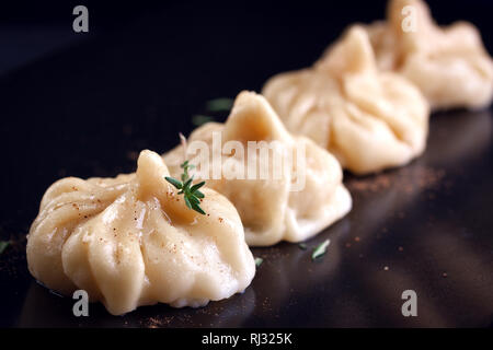 Orientalische Knödel mit Thymin auf einem dunklen Keramikplatte Stockfoto