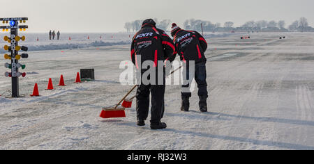 Fair Haven, Michigan - Männer pflegen die Strecke zwischen Snowmobilerennen ziehen sich Anchor Bay von frozen Lake St. Clair. Stockfoto