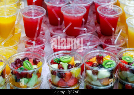 Haufen frisch zubereiteten Obstsalat und gepresste Säfte Stockfoto