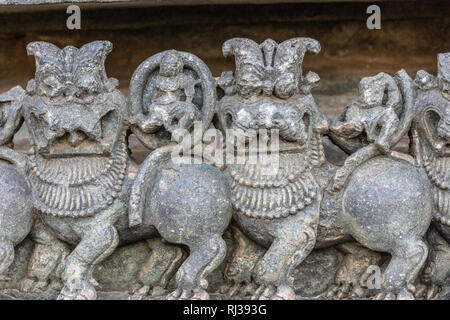 Halebidu, Karnataka, Indien - November 2, 2013: Hoysaleswara Tempel von Shiva. Nahaufnahme von Lion Statuen auf der Seite des Tempels Struktur in grauen Stein und Stockfoto