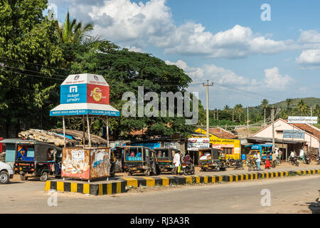 Halebidu, Karnataka, Indien - November 2, 2013: Street View der Stadt in der Nähe von Hoysalaswara Tempel, mit kleinen Autos, Fahrräder und Menschen. Grüner Gürtel Stockfoto