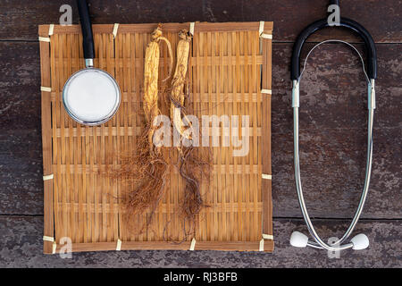 Trockene Ginseng auf Bambus weben mit Stethoskop auf dem Holz Hintergrund Stockfoto