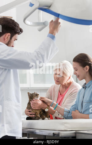 Arzt mit Frau und Mädchen mit Katze in der Tierärztlichen Klinik Stockfoto