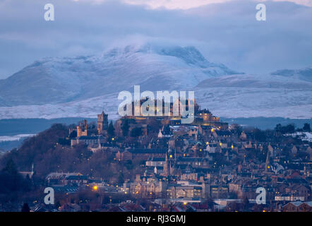 Stirling Castle und Stadt Stirling bei Dämmerung mit dem schneebedeckten Berg (Stuc eine Chroin) im Abstand Stockfoto