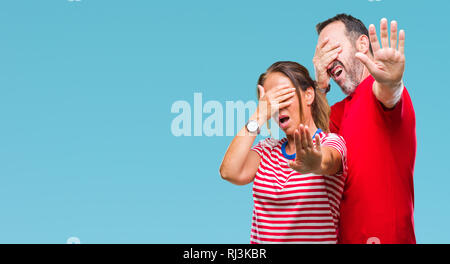 Mittleres Alter spanischer Paar in Liebe über isolierte Hintergrund die Augen mit der Hand und dem Tun stoppen Geste mit traurigen und Angst Ausdruck. Verlegen Stockfoto