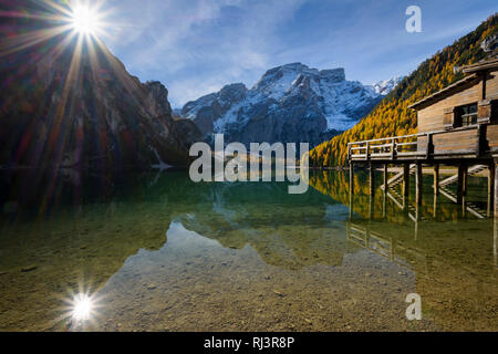 Boot Haus mit Sonne und Croda del Becco, Seekofel, im See im Herbst reflektiert, Pragser See, Lago di Braies, Pragser Wildsee, Provinz Bozen, Bozen Stockfoto