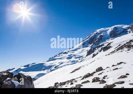 Mount Rainier an einem sonnigen blauen Himmel. In der Ferne sind die Ski Linien auf der Muir Schneefeld. Stockfoto