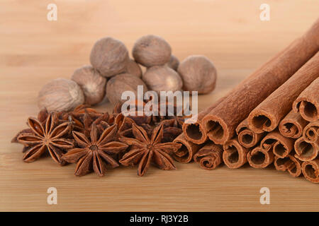 Sternanis, Zimt und Muskatnuss Festlegung auf einen hölzernen Tisch. Geringe Tiefenschärfe. Stockfoto