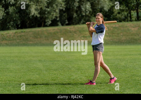 Junge Frau spielt Baseball Stockfoto