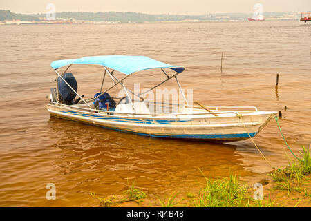 Segeln Motorboot auf schmutzigen Wasser Farbe braun mit grünem Gras Stockfoto