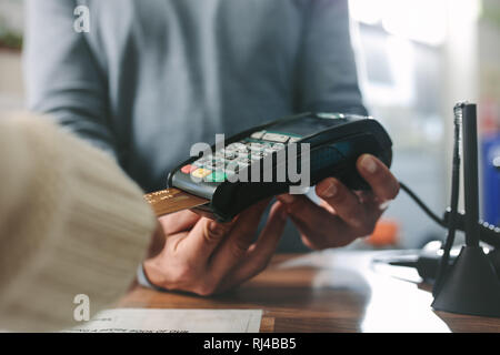 In der Nähe der weiblichen Kunden einfügen Kreditkarte in Payment Terminal der Maschine beim Kauf von Arzneimitteln in der Apotheke. Kunden die Zahlung per Kreditkarte ein Stockfoto