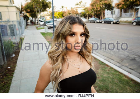 Portrait zuversichtlich, coole Latinx junge Frau auf Nachbarschaft Bürgersteig