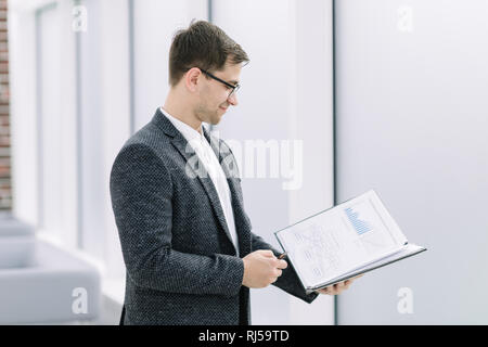 Geschäftsmann mit Klemmbrett in der Nähe von Büro Stockfoto