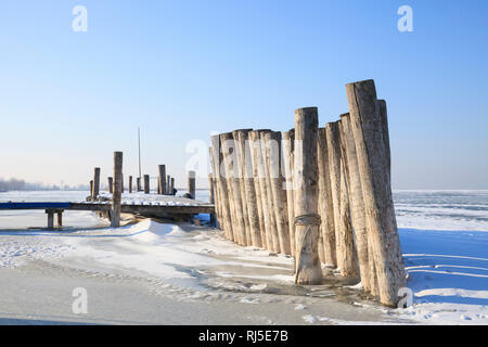 Vereiste Bootsanlegestelle am zugefrorenen Neusiedler See, bei Podersdorf am See, Burgenland, Österreich, Stockfoto