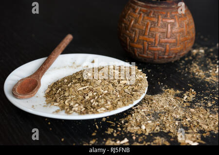 Künstlerische Fotografie der yerba mate Infusion, typische aus Argentinien, in eine weiße Platte, über einen dunklen Hintergrund Stockfoto