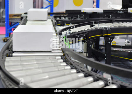 Kartons auf Förderband. Pakete Transport System Konzept Stockfoto
