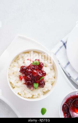 Reis in eine Schüssel Haferbrei mit Cranberry Konfitüre zum Frühstück. Overhead shot, Copyspace. Stockfoto