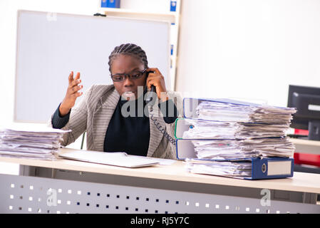 Schwarze weibliche Mitarbeiter mit übermäßiger Arbeit unzufrieden Stockfoto