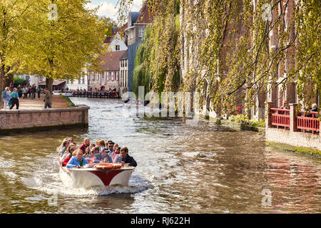 25. September 2018: Brügge, Belgien - Sightseeing Bootsfahrt auf dem Kanal von Brügge an einem sonnigen Herbsttag, Bäume in Herbstfarben. Stockfoto