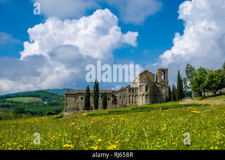 Typische hügelige toskanische Landschaft mit Feldern, Zypressen und der Kirche Pieve di San Pietro ein Romena Stockfoto