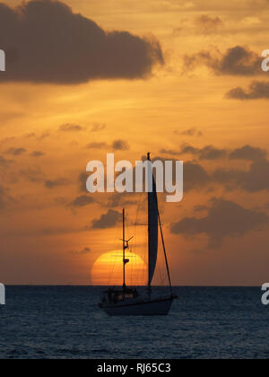 Segelboot in der Ferne am Meer mit Sonnenuntergang Stockfoto