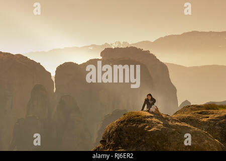 Frau sitzt auf der Felsen von Meteora in Griechenland. Stockfoto