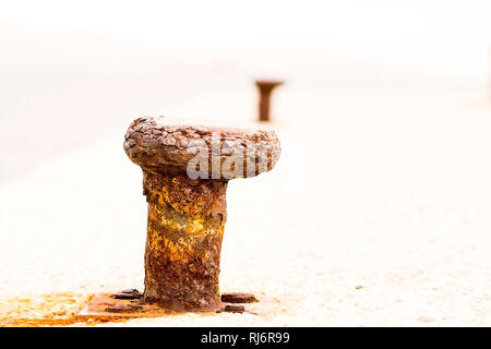 High-key Image von abgenutzten verrostet Poller in der Perspektive mit einer anderen. Die Erosion des Vertrauens Konzept mit kopieren. Stockfoto