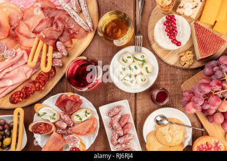 Charcuterie Verkostung. Viele verschiedene Wurst und Schinken, Aufschnitt, und einer Auswahl an Käse, geschossen von oben auf einem urigen Hintergrund Stockfoto