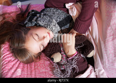 Mädchen, 12 Jahre alt, schlafend mit Stofftier Stockfoto