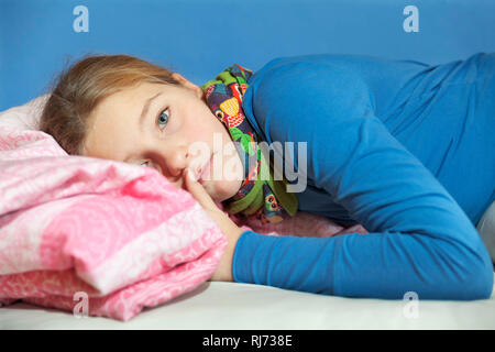 Mädchen, 10 Jahre alt, Porträt, auf dem Bett liegend, traurig Stockfoto