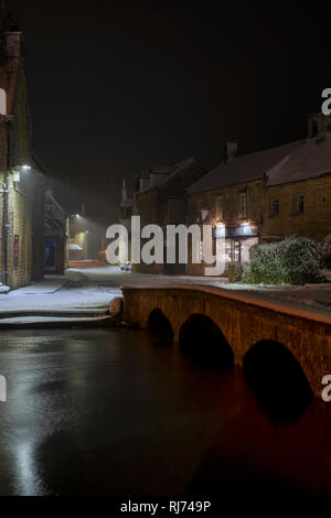 Sherborne Street in Bourton auf dem Wasser am frühen Morgen Schnee vor der Morgendämmerung. Bourton auf dem Wasser, Cotswolds, Gloucestershire, England Stockfoto