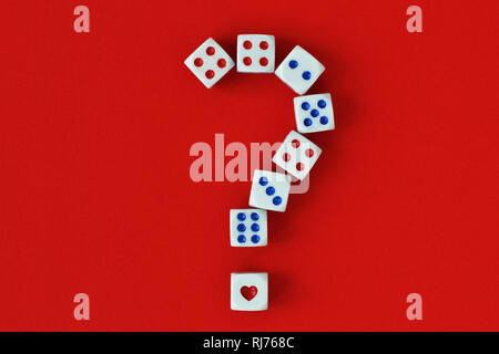 Fragezeichen aus Würfeln und Herzen auf rotem Hintergrund - Begriff des Risikos und der Chance auf Liebe Stockfoto