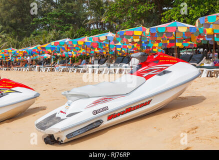 Rot und Weiß Yamaha Waverunner Jetski am Strand vor bunten Sonnenschirme und Liegestühle in Surin Beach, West Coast Pkuket, Thailand Stockfoto