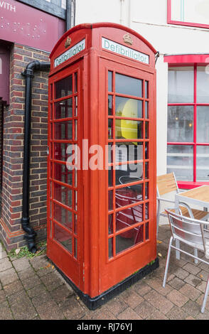 Public Access Defibrillator Maschine in einem alten roten Telefonzelle in Storrington, West Sussex, England, UK. Stockfoto