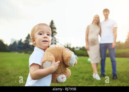 Adorable Junge Spielzeug in den Park mit den Eltern Stockfoto