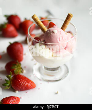 Eine Tasse Eis mit Erdbeeren und rollte Wafer. eis Nahaufnahme. Stockfoto