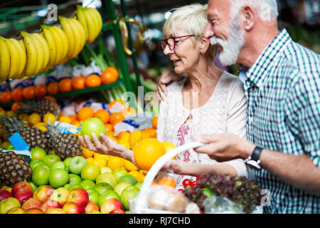 Senior Familie Paar Auswahl bio Lebensmittel Obst und Gemüse auf dem Markt beim wöchentlichen Einkauf Stockfoto