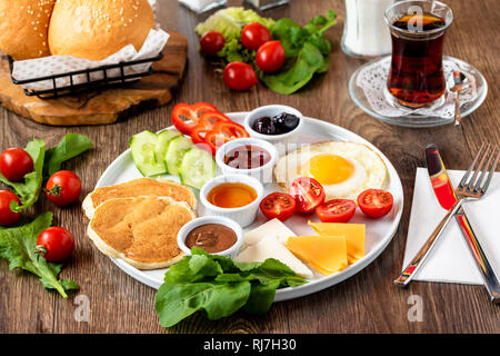 Riesige gesundes Frühstück auf einem Tisch mit Kaffee, Tee, Tomaten, Eier, Pfannkuchen, Marmelade und Käse, Stockfoto