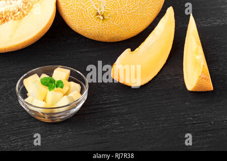 Frischen süßen Orangen Melone auf einem alten schwarzen Holztisch (selektive Fokus). Stockfoto