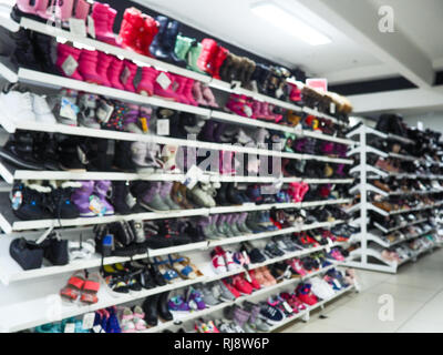 Verschwommen Regalen der Schuhe in einem Schuhgeschäft. Shopping Mall, Mode Schuhe. Stockfoto