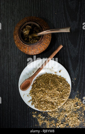 Künstlerische Fotografie der yerba mate Infusion, typische aus Argentinien, in eine weiße Platte, über einen dunklen Hintergrund Stockfoto